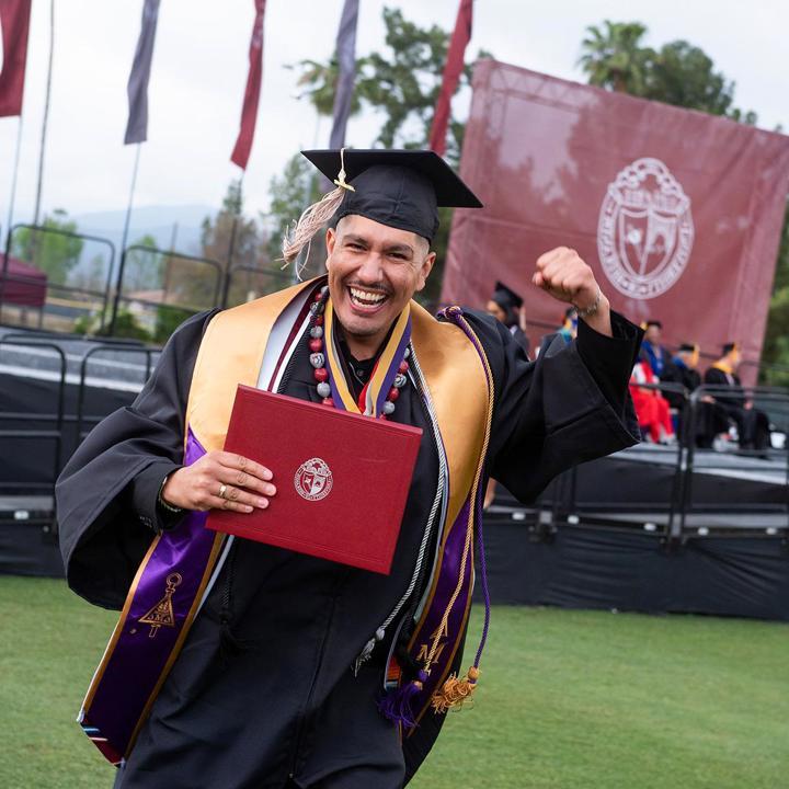 School of Business graduate celebrating receiving their diploma.